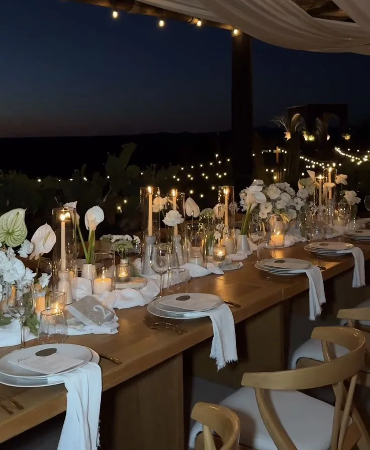 A minimalist table with ivory florals, taper candles and neutral linens
