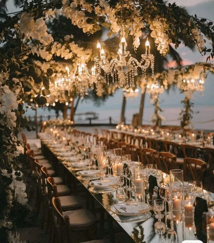 Candlelit tables beneath hanging chandeliers and florals